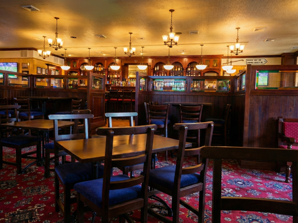 Dining area of Grace O’Malley’s Irish Pub in Norfolk, Virginia, showing timber partition screens, patterned carpet, and warm ambient lighting across seating areas.
