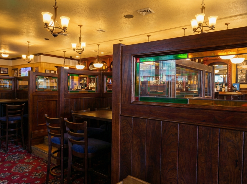 Timber partition screens with stained glass panels in the dining area of Grace O’Malley’s Irish Pub in Norfolk, Virginia, creating semi-private seating zones.