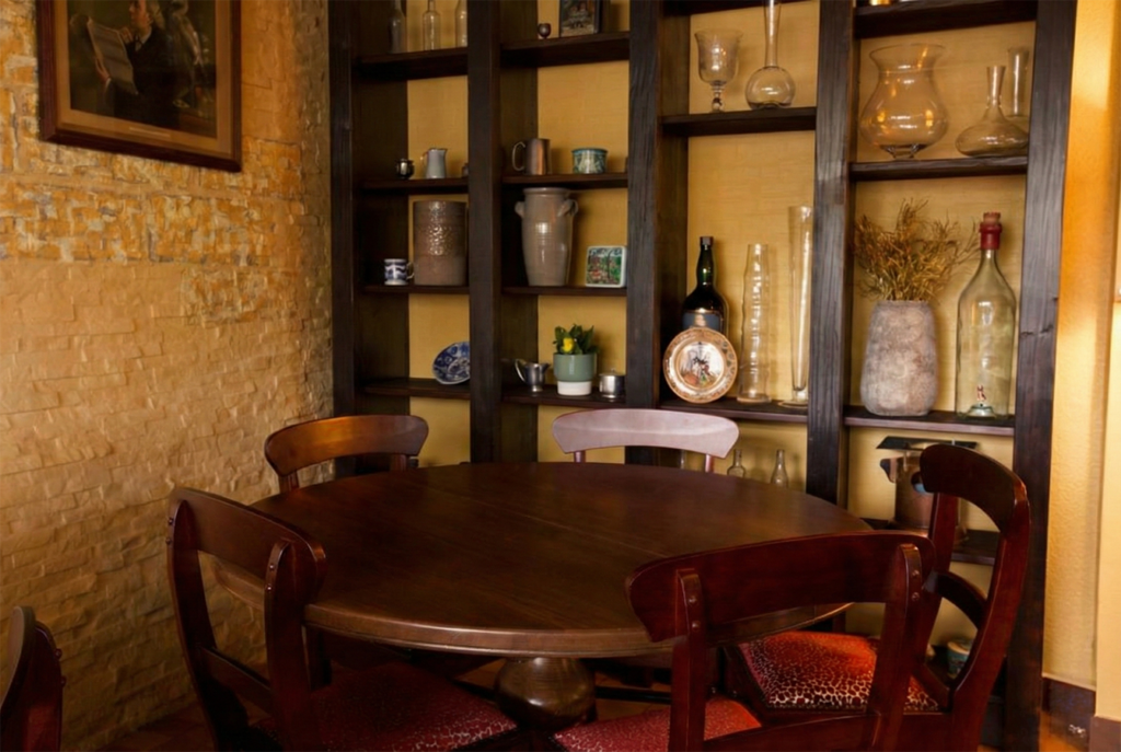 Seating corner with round table, brick wall, and open shelving at Red Piper gastropub in Vevey, Switzerland.